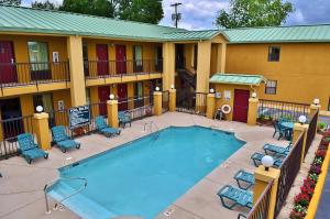 a pool at a hotel with chairs and a building at Executive Inn Opp in Opp