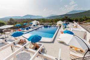 a view of a pool with umbrellas and chairs at Luštica Apartments in Luštica