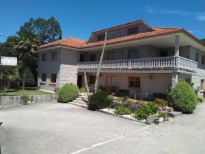 una casa grande con una entrada delante de ella en Hostal - Restaurante Casa Cuña, en Tebra