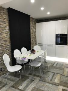 a dining room with a white table and white chairs at Apartment Ajla in Tuzla
