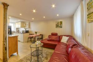 a living room with a red couch and a kitchen at Apparthaus Pfeifer in Baden-Baden