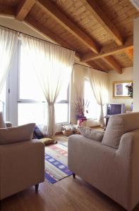 a living room with two couches and large windows at Residence Darsena in Cattolica