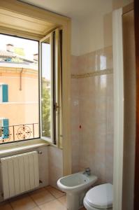 a bathroom with a toilet and a window at Zaffiro Blu Airport in Bergamo