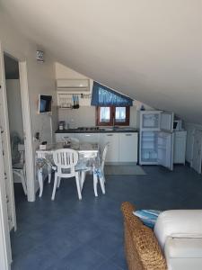 une cuisine et une salle à manger avec une table et des chaises dans l'établissement Mansarda Camelie via dei Normanni, 45, à Campofelice di Roccella