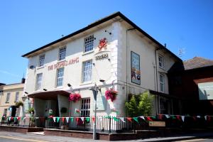 een wit gebouw aan de straatkant bij Thomas Arms Hotel in Llanelli