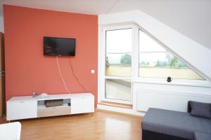 a living room with a tv on a orange wall at Apartmá Kateřina Velké Losiny in Velké Losiny
