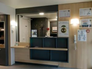 a reception desk with a mirror in a room at B&B HOTEL Amiens in Longueau