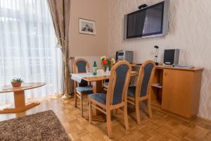 a dining room with a table and chairs and a television at Apartment Vila Golf in Rogaška Slatina