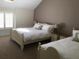 a bedroom with two beds and a window at Riverside Suites Llangollen in Llangollen