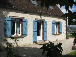 a house with blue shutters on the windows at Tante Pim in Neuilly-sur-Eure