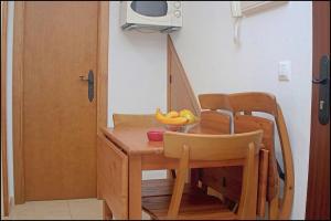 einen Holztisch mit einer Schale Bananen drauf in der Unterkunft Apartamento centro de Conil in Conil de la Frontera
