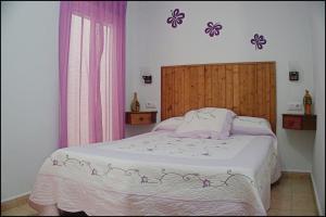 コニル・デ・ラ・フロンテーラにあるApartamento Centro Conilのベッドルーム1室(紫色の花の壁にベッド1台付)