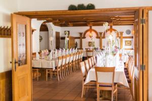a dining room with a long table with white tables and chairs at Gasthof zur Sonne Winzenhohl in Hösbach