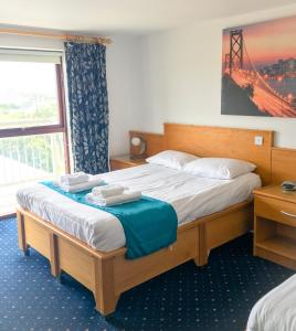 a bedroom with a bed with two towels on it at The Beach Motel in Trearddur