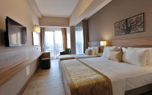 ein Hotelzimmer mit zwei Betten und einem Flachbildfernseher in der Unterkunft Kule Hotel in Canakkale