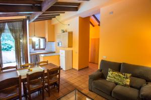 a living room with a couch and a table and a kitchen at Mas Masnou in Olot