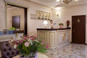 una mujer parada en un bar en el vestíbulo de un hotel en Hotel Legenda en Rostov-on-Don