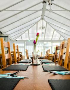 a long wooden table with a vase of flowers on it at The Beach Motel in Trearddur