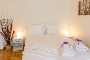 a bedroom with a white bed with two towels at Charmy Petit Flat in Athens in Athens