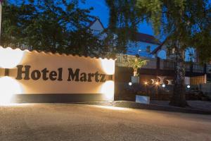 un cartel para el hotel marriot iluminado por la noche en Hotel Martz en Pirmasens