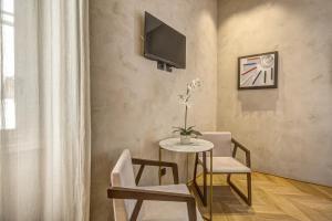 a living room with a table and two chairs and a tv at G55 Design Hotel in Rome