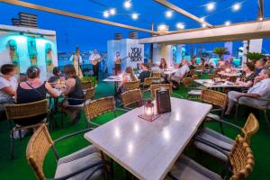 un grupo de personas sentadas en mesas en un restaurante en Mercè, en Pineda de Mar