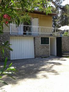 a house with white garage doors and a balcony at Holiday Home Paradizo in Veli Lošinj +15 photos