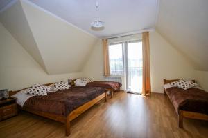 ブコビナ・タトシャンスカにあるWilla Bukowinaの大きな窓付きの客室で、ベッド3台が備わります。