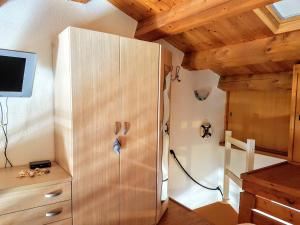 a room with a wooden cabinet and a tv on a ceiling at La Casa di Chris in Golfo Aranci