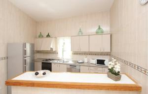 a kitchen with a refrigerator and a table with flowers on it at Casa de Vacaciones Ribot in Ariany