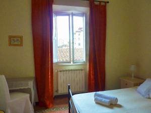 a bedroom with a bed and a window with red curtains at B&B IL TABERNACOLO in Florence