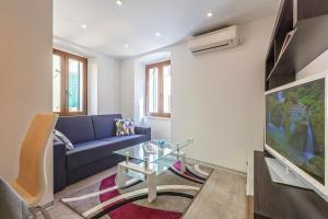 a living room with a blue couch and a tv at Apartment Irene in Poreč