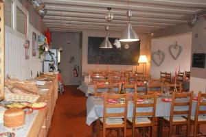 a dining room with tables and chairs with food at Hotel Le Central in La Féclaz