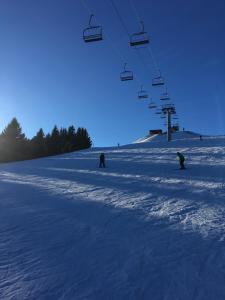 a group of people riding a ski lift in the snow at Hotel Le Central in La Féclaz