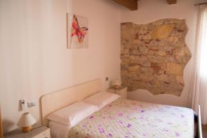 a bedroom with a bed and a brick wall at La Casa del Sogno in Monteforte dʼAlpone