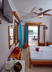 a living room with a bed and a view of the ocean at Pension Dimitris in Votsi