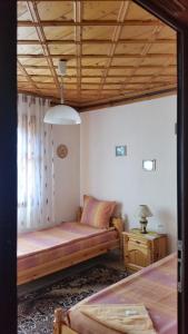 1 dormitorio con 1 cama y 1 mesa con lámpara en Mechta Guest House, en Koprivshtitsa