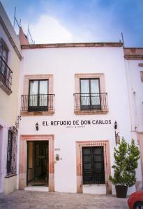 un edificio blanco con las palabras "El refugio de don cartos" en Hotel y Suites El Refugio de Don Carlos en Zacatecas