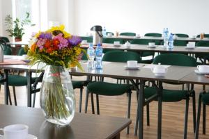 un jarrón lleno de flores sentado en una mesa en Golf Hotel Lisia Polana en Pomocnia
