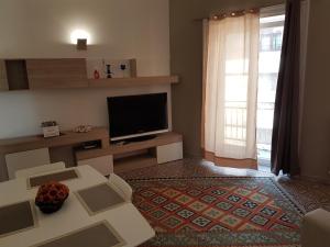 パレルモにあるVittorio Emanuele Appartamentiのリビングルーム(テレビ、ソファ、テーブル付)