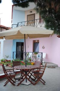 a table and chairs with an umbrella in front of a building at Dafni's Home 50 meters from the beach in Yerakiní