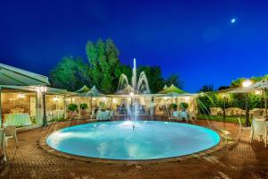 uma piscina à noite com uma fonte em Hotel Piccolo Borgo em Roma