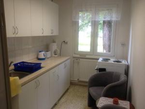 a kitchen with white cabinets and a sink and a window at Chata VI-MA in Patince