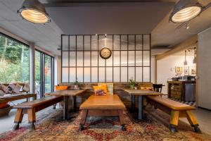 a room with tables and benches and a clock on the wall at V-Hotel in Bonn