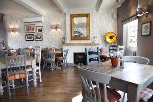 a dining room with a wooden table and chairs at Flower Pot Hotel in Sunbury