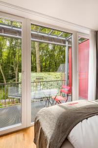um quarto com uma cama e uma porta de vidro deslizante em V-Hotel em Bonn