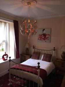 a bedroom with a bed and a chandelier at Craignay Guest House in Inverness