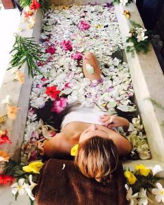 een vrouw die in een bloemenbad ligt bij Villa Velmarie Yoga and Ayurveda house all inclusive in Beruwala