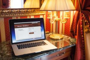 a laptop computer sitting on top of a wooden table at Hotel Manfredi Suite In Rome in Rome