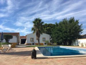 a swimming pool in front of a house at Outeiro Da Vila - Casas De Campo in Vila Verde de Ficalho
